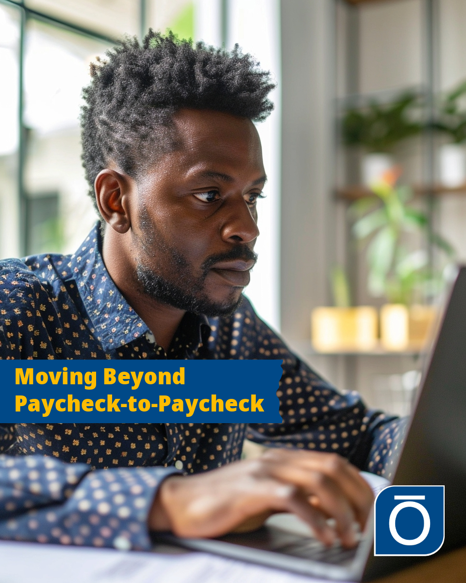 African American man in his thirties looking at a laptop computer screen. Overlay on image reads "Moving Beyond Paycheck-to-Paycheck